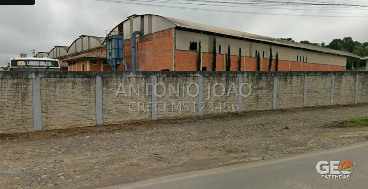 Galpão industrial com muro e calçada